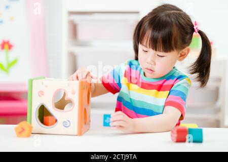 giovane ragazza che gioca numero blocchi forma per homeschooling Foto Stock