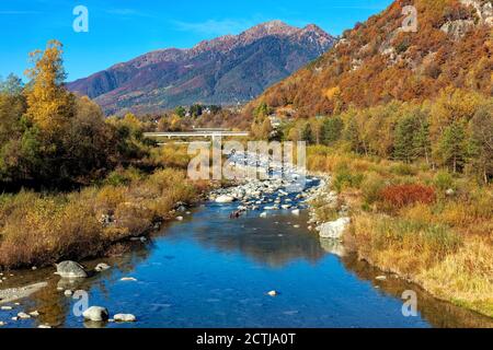 Vista sulle rocce del piccolo fiume alpino tra le colorate montagne autunnali della Svizzera. Foto Stock
