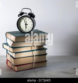 Torna a scuola con libri e orologio su bianco sfondo Foto Stock