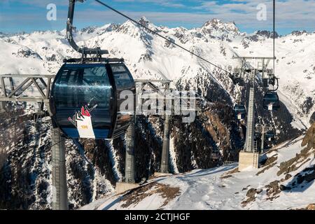 Ischgl, Austria - 10 gennaio 2020: Nuova moderna e spaziosa gondola FimbaBahn contro il paesaggio montano nella lussuosa località invernale austriaca Foto Stock