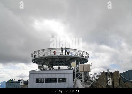 Persone sulle terrazze panoramiche alla stazione di Pointe Helbronner della funivia Monte Bianco di Skyway contro il cielo nuvoloso, Courmayeur, Aosta, Italia Foto Stock