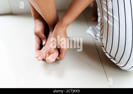 Donna massaggiare il suo piede doloroso e dito, sanitari e medici concetto Foto Stock