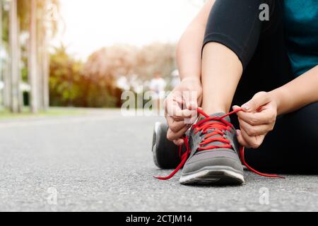 Sport donna passalacci di legatura prima di eseguire le attività outdoor Foto Stock