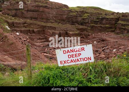 Cartello di avvertenza Danger Deep Excavation presso Marshalls St Bees Quarry, St Bees, Cumbria, Inghilterra, Regno Unito Foto Stock