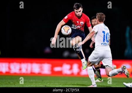 Il calciatore norvegese Ole Selnaes di Shenzhen F.C., a sinistra, protegge la palla durante la sesta partita di 2020 Chinese Super League (CSL) contro di sé Foto Stock