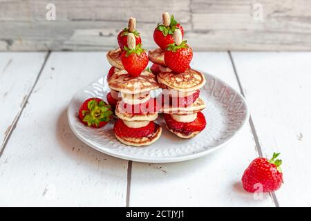 Piatto di mini frittelle con fragole e banane Foto Stock