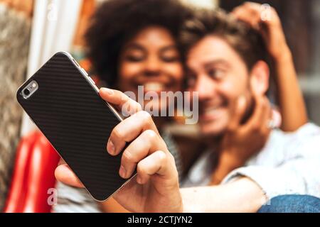 Primo piano di una coppia che prende selfie con smartphone al caffè negozio Foto Stock