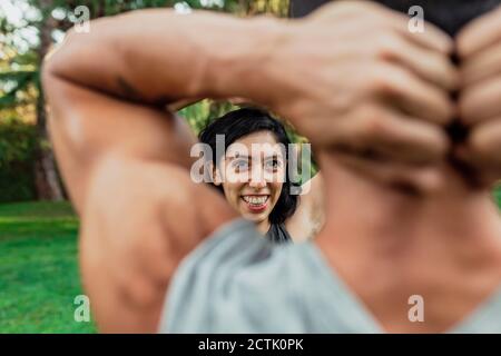 Donna sorridente che si allenava con il ragazzo nel parco Foto Stock
