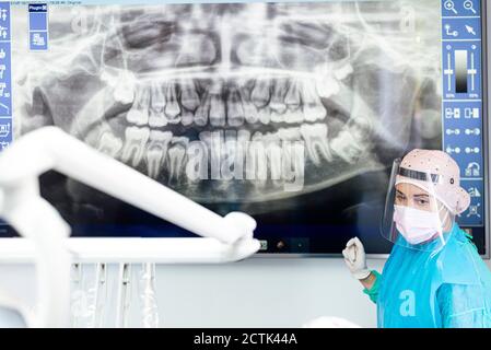 Ortodontista in piedi da radiografia dentale in clinica Foto Stock