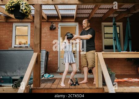 Ragazza con occhiali 3D e padre in veranda Foto Stock