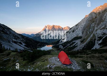 Tenda ambrata in valle di montagna al crepuscolo con Seebensee in sfondo Foto Stock