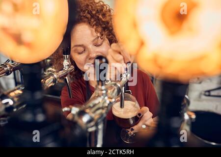 Barkeeper femminile che spillano la birra in un pub Foto Stock