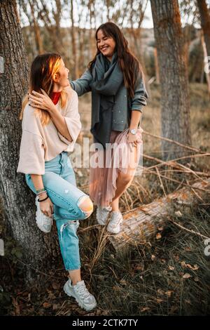 Sorelle felici che trascorrono del tempo nella foresta durante il tramonto Foto Stock