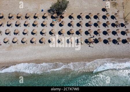 File di sdraio e ombrelloni lungo Potami Beach in estate Foto Stock