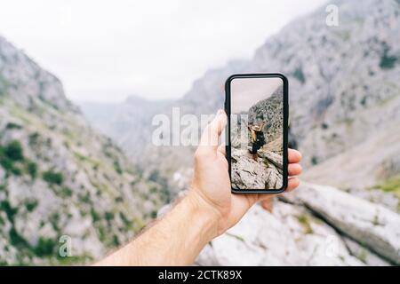 L'uomo tiene il telefono mentre scatta la foto della donna spensierata a Ruta del Cares, Asturias, Spagna Foto Stock