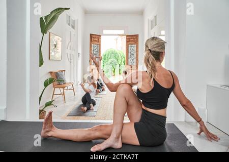 Istruttore femminile che guida le donne nell'esercizio presso lo studio di yoga Foto Stock