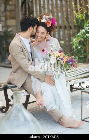 Sposa e sposo che flirtare mentre si siede sulla panchina Foto Stock