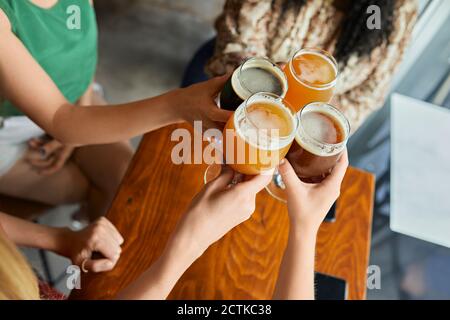 Amici femminili che sorseggiano bicchieri di birra artigianale in un pub Foto Stock