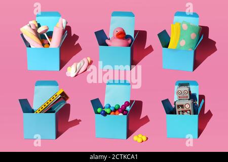 Modello di scatole con vari regali costituiti da armonica, sfere di plastica, giocattolo robot vintage, dolci, anatra di gomma e paio di calze Foto Stock