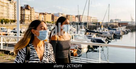 Giovani donne che indossano maschera protettiva in città Foto Stock