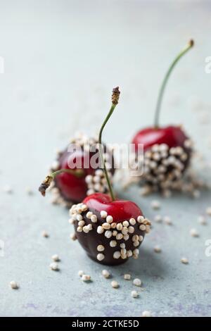 Primo piano di ciliegie ricoperte di cioccolato e quinoa sul tavolo Foto Stock