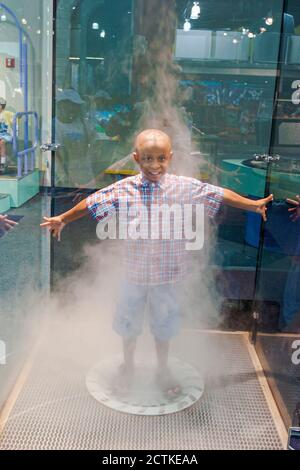 Huntsville, Alabama, Sci-quest Hands-on Science Center, all'interno dell'interno Black African ragazzo che si divertono movimento, simulatore di tornado vorticoso nebbia d'acqua Foto Stock