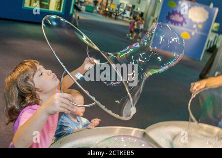 Huntsville, Alabama, Sci-quest Hands-on Science Center, ragazza interna che fa gigantesche bolle di sapone bolla Foto Stock