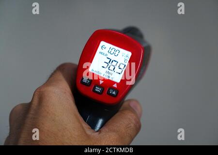 Termometro elettronico per uso medico con indicatori di temperatura corporea elevata, COVID-19, su un bianco sfondo Foto Stock