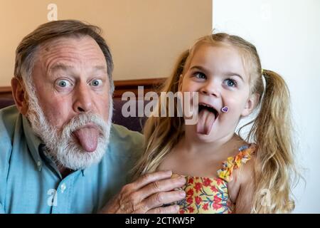 Lily, 3 anni, recita sciocco con il nonno Horton Foto Stock