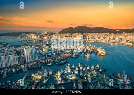 Skyline di Busan e molo al tramonto a Busan, Corea del Sud. Foto Stock