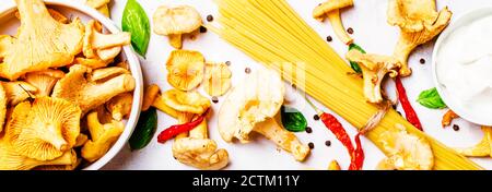 Ingredienti per cucinare la pasta con i finferli di funghi in una salsa cremosa, striscione, vista dall'alto Foto Stock