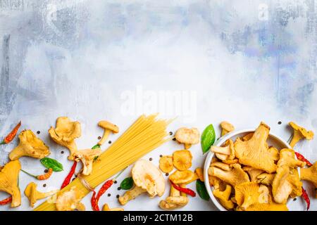 Ingredienti per cucinare la pasta con i finferli di funghi in una salsa cremosa, sfondo del cibo, vista dall'alto Foto Stock