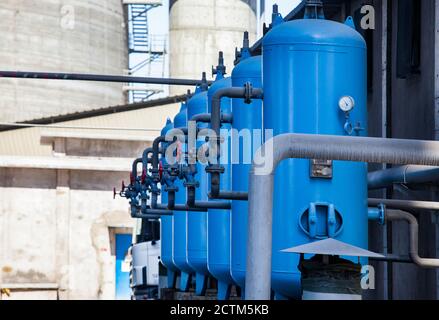 Mynaral/Kazakhstan - Aprile 23 2012: Stabilimento di cemento Jambyl. Stazione di purificazione dell'acqua. Serbatoi blu di stoccaggio dell'acqua con valvole e tubi. Foto Stock