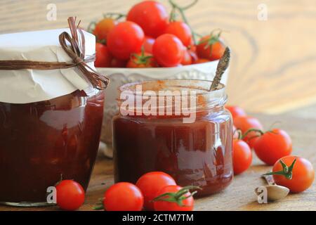Conserve di pomodoro di ciliegia e confettura di peperoncino in un vasetto Foto Stock