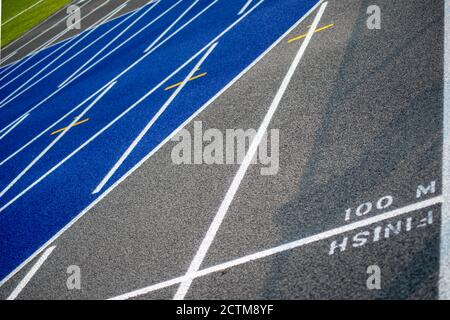 Tracciafile di finitura da 100 M su blu e grigio testurizzato pista da corsa Foto Stock