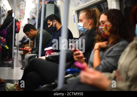 Pendolari su un treno metropolitano della linea Jubilee di Londra mentre si dirigono verso il centro di Londra, dopo che il primo ministro Boris Johnson ha annunciato una serie di nuove restrizioni per combattere l'aumento dei casi di coronavirus in Inghilterra. Foto Stock