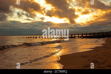 Portobello, Edimburgo, Scozia, Regno Unito. 24 settembre 2020. 6 gradi all'alba, il sole lento a sbirciare attraverso la spessa nuvola sull'orizzonte per riflettere fuori delle acque del Firth of Forth. Foto Stock