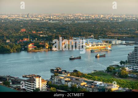 Paesaggio di Bangkok dall'alto, magazzini e fabbriche sul lungofiume. Grande nave da carico parcheggiata e ci sono molte barche nella zona industriale in Foto Stock