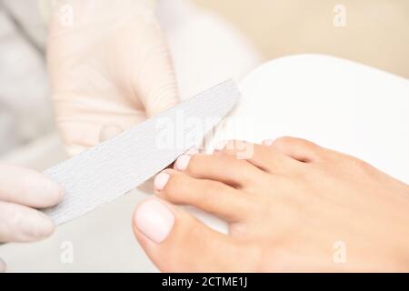 Manicure classica con unghie rosa su sfondo bianco. Concetto di trattamento spa Foto Stock