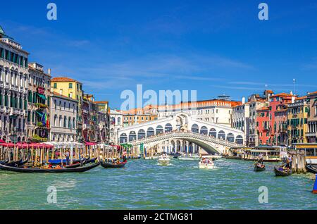 Venezia, Italia, 13 settembre 2019: Paesaggio urbano con il Ponte di Rialto attraverso il Canal Grande, architettura veneziana edifici colorati, gondole, barche, vaporetti ormeggiati e vela Canal Grande Foto Stock