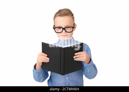 Carino studente serio legge libro e indossare occhiali mentre in piedi in studio, isolato su bianco Foto Stock