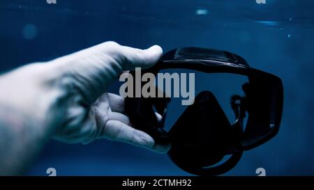 immagine ritagliata della mano maschio sotto la maschera di tenuta dell'acqua. Foto di alta qualità Foto Stock