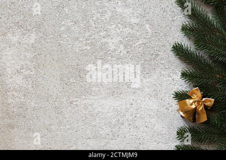 Sfondo in cemento chiaro con elementi decorazioni natalizie. Albero di Natale e campana di natale dorata, vista dall'alto, spazio di copia, Foto Stock