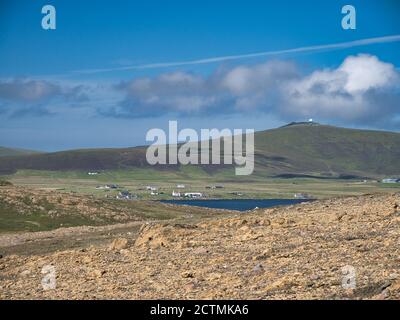 Depositi di roccia serpentina presso la riserva naturale di Hamar vicino a Baltasound sull'isola di Unst, Shetland, Regno Unito. La cupola bianca della RAF Saxa V. Foto Stock