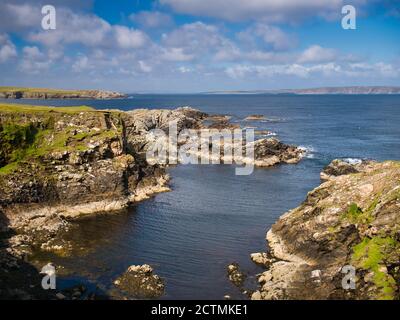 Suggestivo scenario costiero che mostra strati rocciosi inclinati ed erosi intorno al Ness di Queyon, vicino a Otters Wick sull'isola di Yell a Shetland, Regno Unito Foto Stock