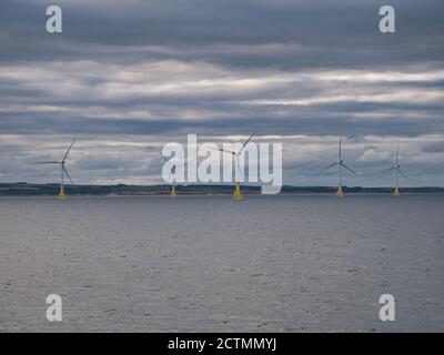 Turbine eoliche al largo delle coste di Aberdeen in Scozia, Regno Unito, prese in una giornata tranquilla con un cielo sovrastato Foto Stock