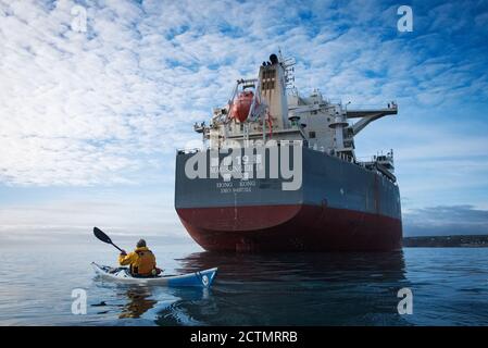 Kayak da mare dwarfed dal portarinfuse Magsenger 19 a Mounts Bay, Cornovaglia Foto Stock