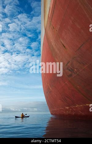 Kayak da mare dwarfed dal portarinfuse Magsenger 19 a Mounts Bay, Cornovaglia Foto Stock