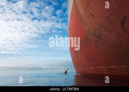 Kayak da mare dwarfed dal portarinfuse Magsenger 19 a Mounts Bay, Cornovaglia Foto Stock