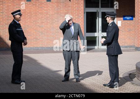 Il primo ministro Boris Johnson durante una visita alla sede centrale della polizia del Northamptonshire a Northampton con il vice capo Constable, Simon Nickless (destra), dove ha incontrato nuove reclute e ha visto una formazione di classe in primo soccorso. Foto Stock